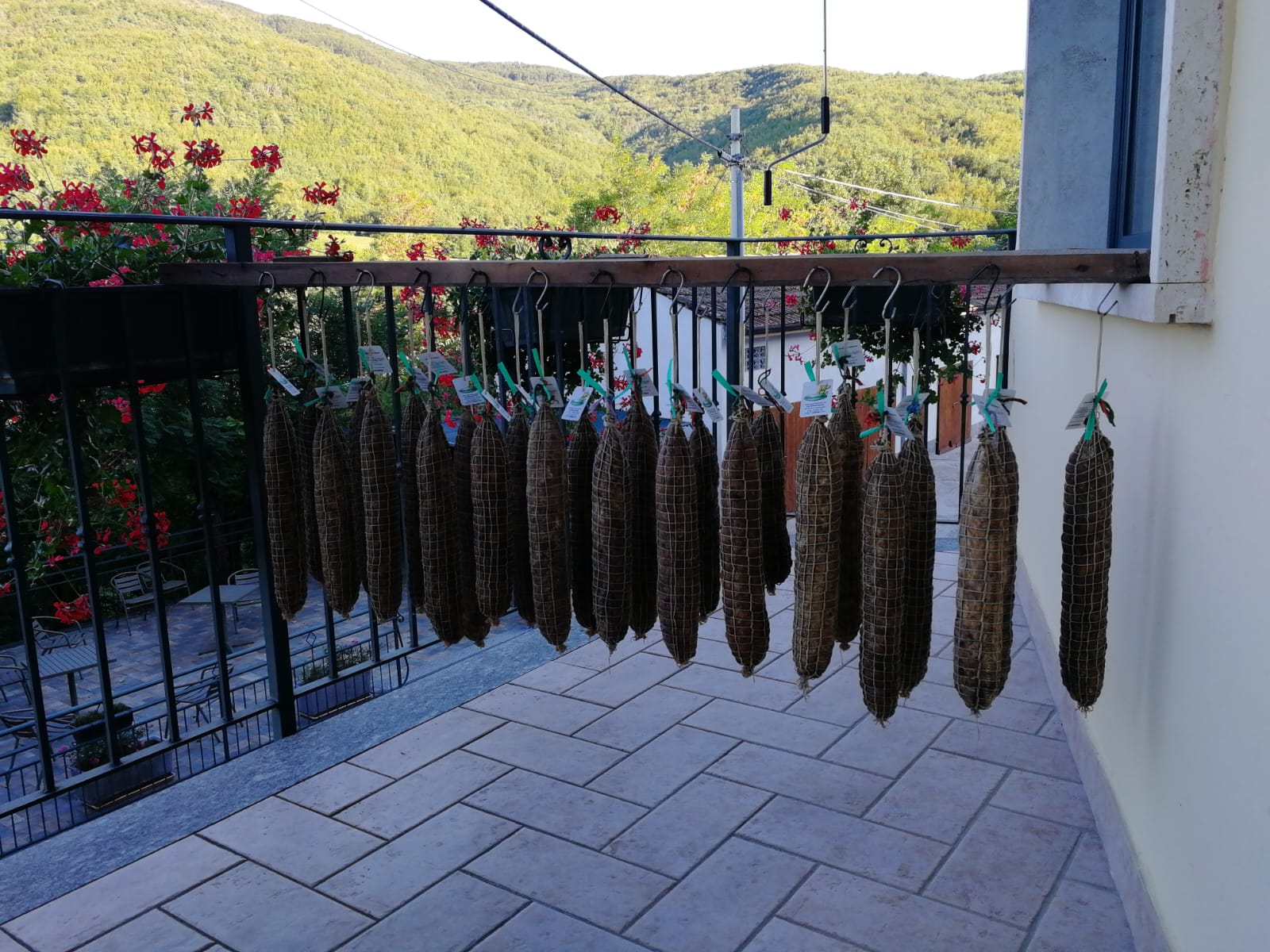 Salame di Varzi stagionato appeso con vista sulle colline dell'Oltrepò Pavese, Ristorante La Ginestrella