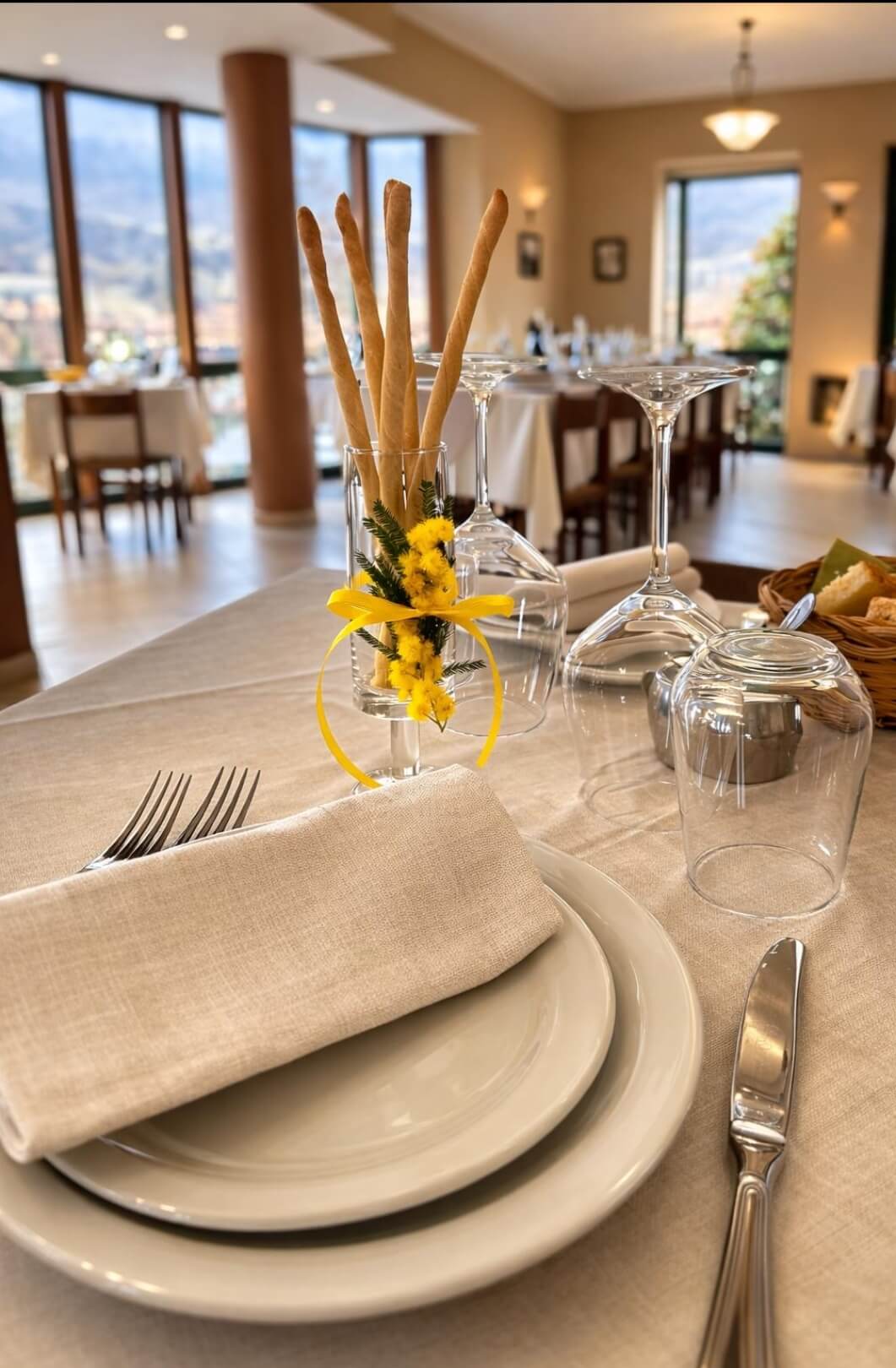 Tavolo apparecchiato con mimosa nella sala del Ristorante La Ginestrella – Varzi, Oltrepò Pavese